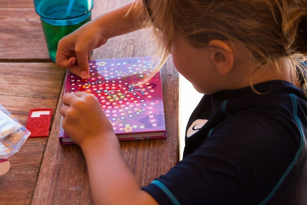 Child playing with Craft Time Mosaics, a great travel tip for families